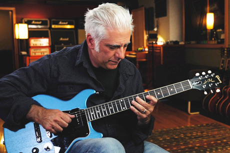 Rick Beato in his studio playing a blue guitar